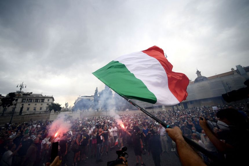 A protester holds an Italian flag as he takes part in a demonstration in Piazza del Popolo in Rome on July 24, 2021.