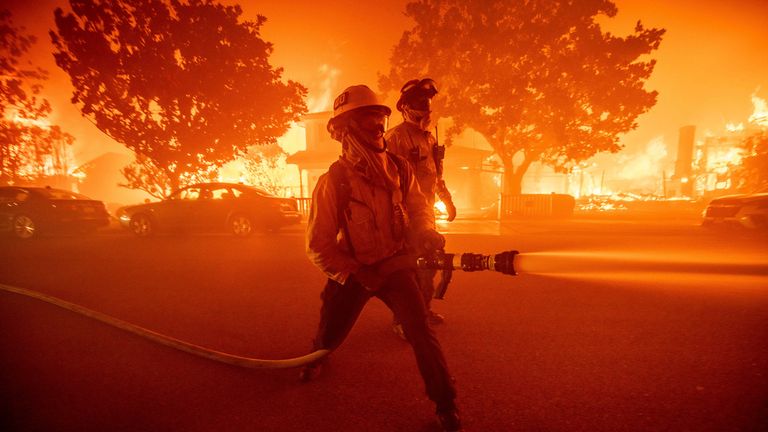 Firefighters battle the Palisades Fire as it burns multiple structures in the Pacific Palisades neighborhood of Los Angeles, Tuesday, Jan. 7, 2025. (AP Photo/Ethan Swope)